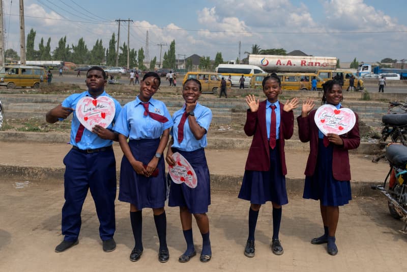 Sanctum Startup College students in uniform holding Love in Action signs during a community outreach event